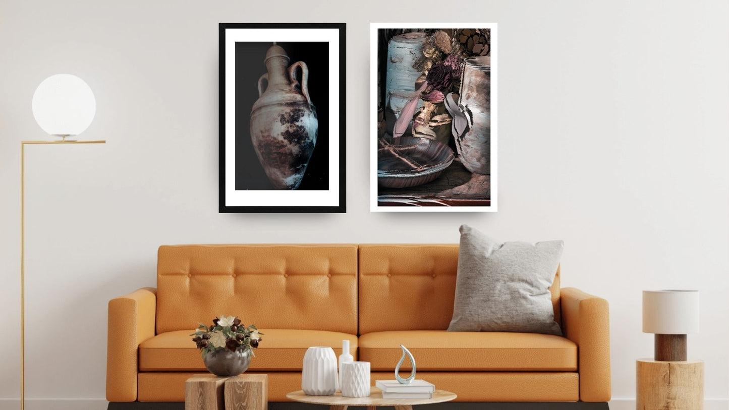 Two framed dark moody still life photo prints of antique clay jars and pottery hang over an orange sofa. Excellent for contemporary wall decor. Wall art frames by wall and more
