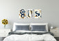 A triptych of three vertical abstract graphic artworks. Each piece features fluid, coiled, ribbon-like shapes in deep navy blue and ochre/gold, often intertwined with thin, black geometric rectangular outlines that sometimes contain or interact with the curves, all set against a pale cream background. Canvas wall art in a bed room by wall and more