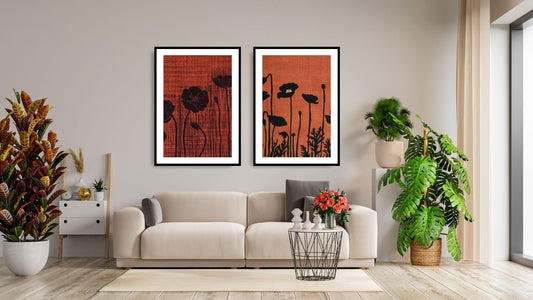 Minimalist Floral Diptych Wall Art Set (2 framed prints) featuring dramatic black Botanical Silhouettes (Poppies) against a textured, deep Terracotta Red background. Ideal Bohemian or Modern Living Room Decor.