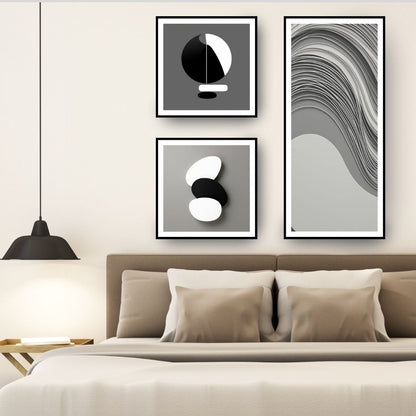 Monochromatic Abstract Art Set (3 framed prints) featuring minimalist black, white, and gray geometric shapes, including a long panel with Wavy Lines and two square panels with stacked forms. Ideal Modern Bedroom Decor.