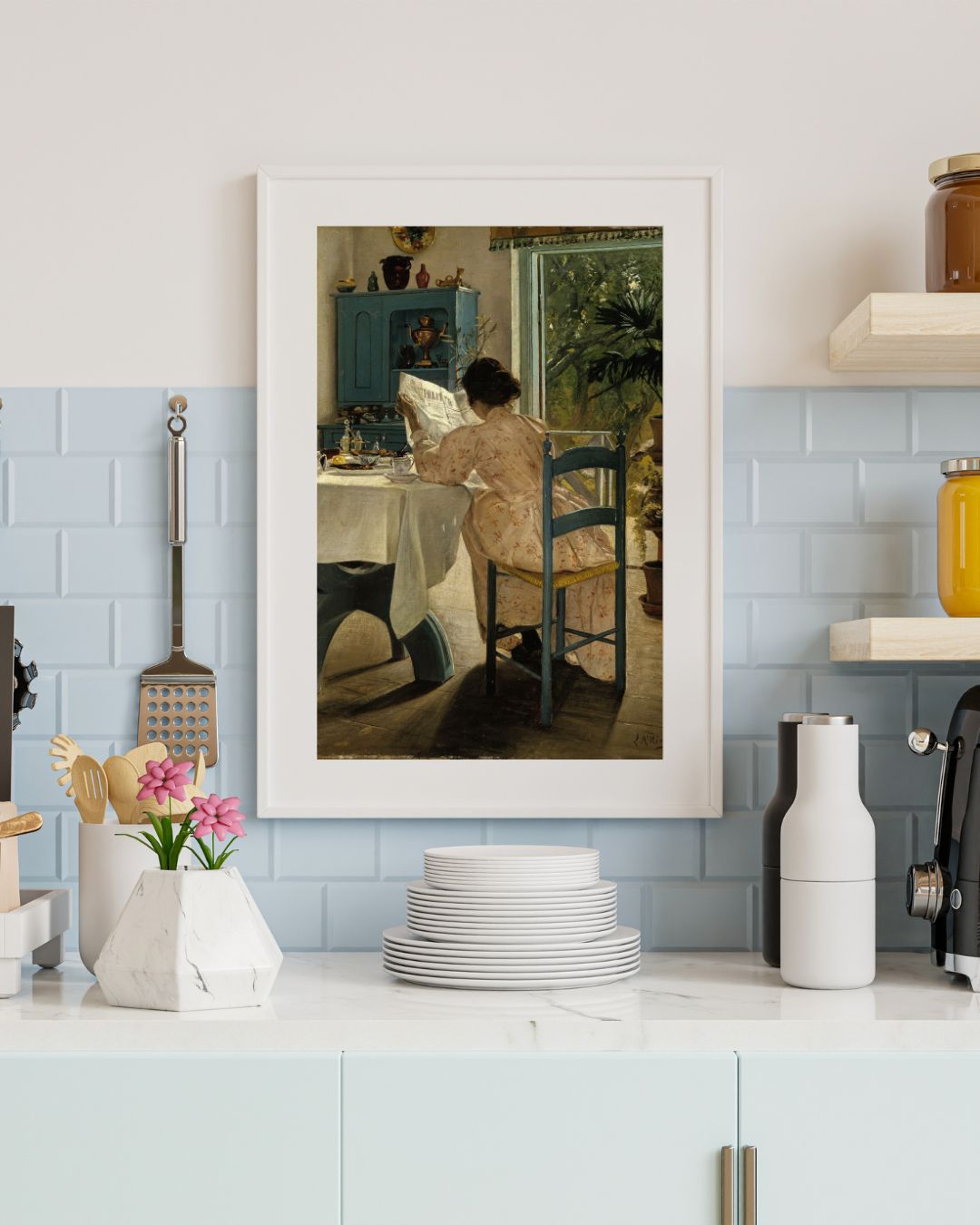 A wall art frame depicting a woman seated at a breakfast table, hung on a wall in a kitchen setting.