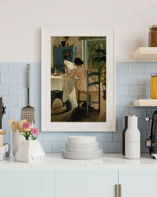 A wall art frame depicting a woman seated at a breakfast table, hung on a wall in a kitchen setting.