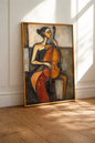 Large figurative canvas wall art depicting a woman playing the cello in warm earth tones, displayed on the floor of a luxury living room
