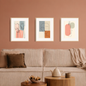 Minimalist abstract line art triptych wall art with soft neutral and terracotta tones displayed above a modern sofa